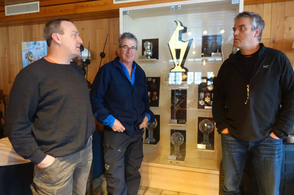 Trois guides de montagne devant les trophées de Didier Cuche 